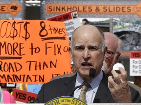 FILE - In this April 5, 2017, file photo, California Gov. Jerry Brown urges lawmakers to approve SB1, a bill to raise gas and car taxes to generate $5 billion-a-year for road repairs, during a rally in Sacramento, Calif. As the political battle to overturn the gas tax increase intensified, the state transportation agency coordinated frequently with the public relations firm working to block the repeal on behalf of unions, construction companies and local governments, emails obtained by The Associated Press show.