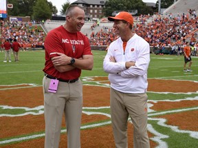 Clemson head coach Dabo Swinney, right, speaks with North Carolina State head coach Dave Doeren before the first half of an NCAA college football game against NC State Saturday, Oct. 20, 2018, in Clemson, S.C.