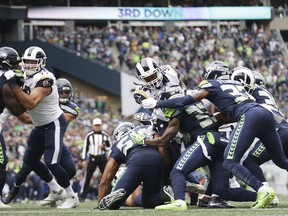 Los Angeles Rams running back Todd Gurley, center, is stopped by the Seattle Seahawks defense, including free safety Tedric Thompson (33) on a third-down goal line drive during the first half of an NFL football game, Sunday, Oct. 7, 2018, in Seattle. The Rams kicked a field goal on the next play.