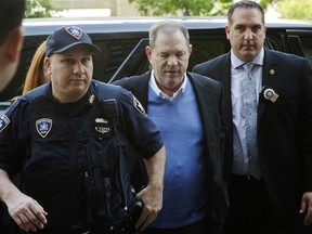 In this May 25, 2018 file photo, NYPD Detective Nicholas DiGaudio, right, escorts Harvey Weinstein into court in New York.