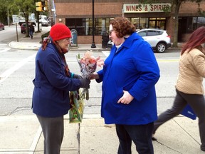 Kristin Wessell, right, hands a bouquet of flowers to Marianne Novy on Murray Avenue in the Squirrel Hill neighbourhood of Pittsburgh, Monday, Oct. 29, 2018.