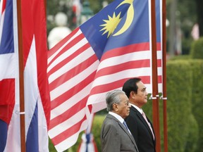 Malaysian Prime Minister Mahathir Mohamad, front, and Thailand's Prime Minister Prayuth Chan-ocha listen to their national anthems during a welcoming ceremony at the government house in Bangkok, Thailand, Wednesday, Oct. 24, 2018. Mahathir on Wednesday began a two-day visit to Thailand during which he's expected to discuss peace talks in southern border provinces with Malaysia, where a Muslim separatist insurgency has been raging for over a decade.