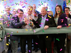 MLA Nathan Cooper, left, Sundial CEO Torsten Kuenzlen, centre, and Olds Mayor Michael Muzychka cut the ribbon at the official opening of Sundial Growers' marijuana facility in Olds, Alta., on Oct. 10, 2018.