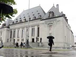 The Supreme Court of Canada building is pictured in Ottawa on Wednesday October 15, 2014. Three former security guards at the Quebec legislature who were fired after they were caught using a camera to spy on guests at a neighbouring hotel can grieve their dismissals, the Supreme Court of Canada ruled Friday.