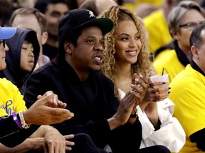 FILE - In this April 28, 2018, file photo, Jay-Z and Beyonce watch Game 1 of an NBA basketball second-round playoff series between the Golden State Warriors and the New Orleans Pelicans in Oakland, Calif. Beyonce paid homage to a high-profile music executive being honored at a charity event to raise money for cancer research.