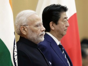 Japan's Prime Minister Shinzo Abe, right, and India's Prime Minister Narendra Modi observe an honor guard ahead of a meeting at Abe's official residence in Tokyo Monday, Oct. 29, 2018.