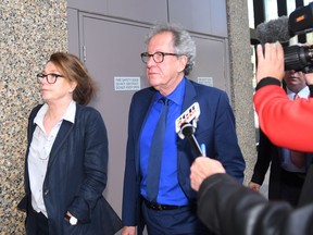 Australian actor Geoffrey Rush, center, leaves the Federal Court in Sydney, Australia Monday, Oct. 22, 2018. The actor faced a large media pack Monday as he entered Sydney's Federal Court, where a judge is hearing his defamation trial against Sydney's Daily Telegraph and its journalist Jonathon Moran.
