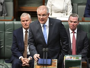 Australian Prime Minister Scott Morrison, center, delivers a formal apology to Australia's victims of child sex abuse in the House of Representatives at Parliament House in Canberra, Monday, Oct. 22, 2018. His emotional speech delivered in Parliament before hundreds of survivors followed the conclusions of a Royal Commission into Institutional Responses to Child Sexual Abuse, the nations' highest level of inquiry.