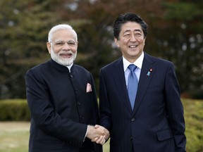 India's Prime Minister Narendra Modi, left, shakes hands with Japan's Prime Minister Shinzo Abe in Yamanakako village, Yamanashi prefecture, Sunday, Oct. 28, 2018.