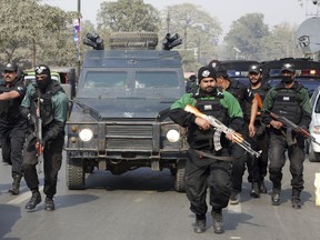 FILE-- In this Feb. 7, 2018, file photo, Pakistani police commandos escort a police van carrying Mohammad Imran, who is accused of the brutal killings of eight children in the eastern city of Kasur, as it arrives at an anti-terrorist court, in Lahore, Pakistan. The serial killer of eight children was executed at a Pakistani prison Wednesday morning, Oct. 17, 2018, after the country's top court rejected a request for his public hanging, officials said.