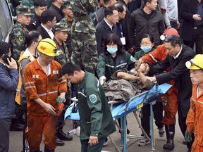 In this photo released by China's Xinhua News Agency, a worker is carried on a stretcher out of the Longyun coal mine in Yuncheng County, east China's Shandong Province, Sunday, Oct. 21, 2018. Twenty were trapped in the coal mine Sunday after a rock burst destroyed part of a mining tunnel.