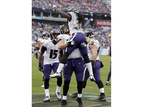 Baltimore Ravens running back Alex Collins (34) is picked up by guard Marshal Yanda after Collins scored a touchdown against the Tennessee Titans in the first half of an NFL football game Sunday, Oct. 14, 2018, in Nashville, Tenn.