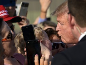 President Donald Trump goes to give a baby a kiss as he greets people after arriving at Tri-Cities Airport in Blountville, Tenn., Monday, Oct. 1, 2018. Trump is in Tennessee to speak at a rally in Johnson City.