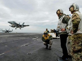 NATO Secretary General, Jens Stoltenberg looks on October 12, 2018, at a F-18 Super Hornet landing on the aircraft carrier USS Harry S. Truman in the North Sea. The aircraft carrier is on its way to the Norwegian Coast to participate in the NATO exercise Trident Juncture.