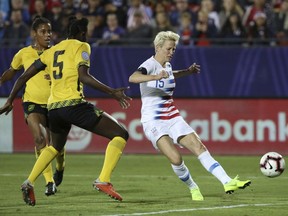 United States forward Megan Rapinoe scores a goal while being defended by Jamaica defender Konya Plummer during the first half of a CONCACAF women's World Cup qualifying tournament soccer match in Frisco, Texas, Sunday, Oct. 14, 2018.