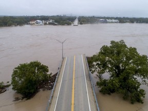 The Llano River flows between the washed out Ranch Road 2900 bridge, Tuesday, Oct. 16, 2018, in Kingsland, Texas.
