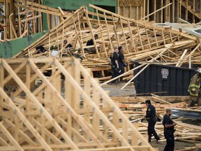 Emergency workers attempt to rescue people trapped under a three-story structure under construction that collapsed in Dallas, Monday, Oct. 8, 2018. A construction worker is dead and five co-workers are hospitalized with injuries after a three-story town house they were building west of downtown Dallas collapsed during a thunderstorm.