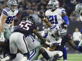Dallas Cowboys quarterback Dak Prescott (4) is held short of a first down during the first half of an NFL football game against the Houston Texans, Sunday, Oct. 7, 2018, in Houston.