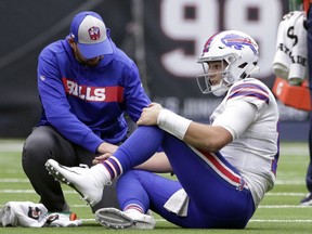 Buffalo Bills quarterback Josh Allen (17) is check on after he was injured during the second half of an NFL football game against the Houston Texans, Sunday, Oct. 14, 2018, in Houston.