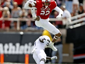 Texas Tech's Seth Collins (22) leaps over Kansas' Mike Lee (11) during the first half of an NCAA college football game Saturday, Oct. 20, 2018, in Lubbock, Texas.