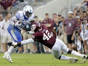 Kentucky running back Benny Snell Jr. (26) is tackled on his run by Texas A&M linebacker Otaro Alaka (42) during the first half of an NCAA college football game Saturday, Oct. 6, 2018, in College Station, Texas.