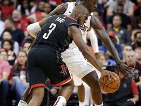 Houston Rockets guard Chris Paul (3) is fouled as he drives into New Orleans Pelicans guard Jrue Holiday, right, during the first half of an NBA basketball game Wednesday, Oct. 17, 2018, in Houston.