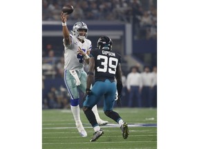 Dallas Cowboys quarterback Dak Prescott (4) passes under pressure from Jacksonville Jaguars free safety Tashaun Gipson Sr. (39) in the first half of an NFL football game in Arlington, Texas, Sunday, Oct. 14, 2018.