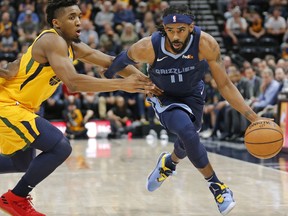 Memphis Grizzlies guard Mike Conley (11) drives around Utah Jazz guard Donovan Mitchell, left, in the first half of an NBA basketball game Monday, Oct. 22, 2018, in Salt Lake City.