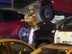 A law enforcement officer walks near the South Medical Tower on the University of Utah campus during a search for a man they say shot and killed a University of Utah student outside of a dormitory on campus, the Salt Lake Tribune reported Monday, Oct. 22, 2018, in Salt Lake City. The female student's body was found in a car near the medical towers, University of Utah Police Lt. Brian Wahlin said. The man they are searching for and the student had "a previous relationship," Wahlin said.