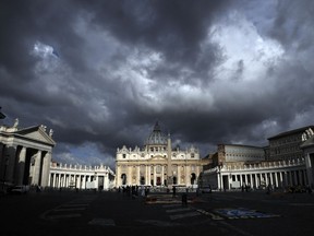 FILE - In this June 29, 2017 file photo, clouds hang over St. Peter's Basilica, at the Vatican.  Despite the dark cloud hanging over a synod of bishops which opens Wednesday, Oct. 3, 2018, organizers said Monday they thought the rebirth of the scandal could still give the Vatican an opportunity to show that the Catholic Church isn't just about sex abuse and cover-ups.