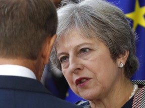 British Prime Minister Theresa May, right, speaks with European Council President Donald Tusk after a group photo an EU-ASEM summit in Brussels, Friday, Oct. 19, 2018. EU leaders met with their Asian counterparts Friday to discuss trade, among other issues.