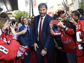 Washington Capitals' Alex Ovechkin, center, of Russia, walks the red carpet before their opening season NHL hockey game against the Boston Bruins, Wednesday, Oct. 3, 2018, in Washington.