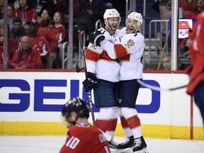 Florida Panthers center Colton Sceviour (7) celebrates his goal with left wing Jonathan Huberdeau (11) during the first period of an NHL hockey game as Washington Capitals right wing Brett Connolly (10) sits on the ice, Friday, Oct. 19, 2018, in Washington.