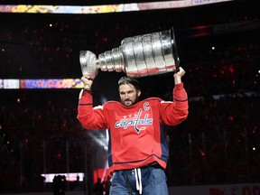 Washington Capitals left wing Alex Ovechkin, of Russia, carries the Stanley Cup during a banner-raising ceremony before the team's NHL hockey game against the Boston Bruins, Wednesday, Oct. 3, 2018, in Washington.