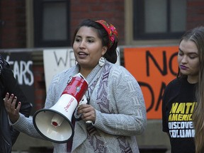 In this 2016 photo provided by Jason Packineau, Danielle Lucero, center, of Isleta Pueblo, New Mexico, speaks during Indigenous Peoples' Day at Harvard University in Cambridge, Mass.  The clash between Massachusetts Sen. Elizabeth Warren and President Donald Trump over her Native American heritage highlights the varying methods tribes use to decide who belongs.  The decision has wide-ranging consequences for Native American communities and their relationship with the federal government.