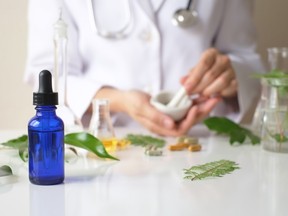the scientist or doctor make herbal medicine from herb in the laboratory on the table .alternative treatment. show hand and stethoscope. with the bottle container.