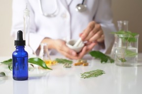 the scientist or doctor make herbal medicine from herb in the laboratory on the table .alternative treatment. show hand and stethoscope. with the bottle container.