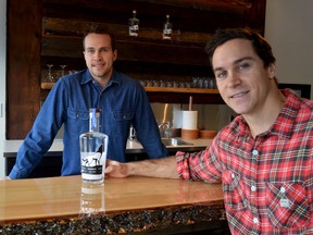 Keith Robinson, left, and Matt Widmer, right, at the handmade bar of their new distillery called Wild Life Distillery, in Canmore Alta., with one of the first bottles of vodka on December1, 2016.