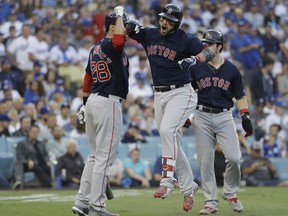 Boston Red Sox's Steve Pearce celebrates with J.D. Martinez (28) and Andrew Benintendi after hitting a two-run home run during the first inning in Game 5 of the World Series baseball game on Sunday, Oct. 28, 2018, in Los Angeles.