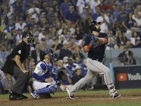 Boston Red Sox's Mitch Moreland watches his three-run home run during the seventh inning in Game 4 of the World Series baseball game against the Los Angeles Dodgers on Saturday, Oct. 27, 2018, in Los Angeles. Left is home plate umpire Chad Fairchild and Los Angeles Dodgers catcher Austin Barnes.