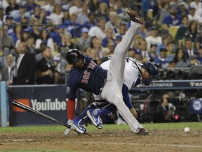 Boston Red Sox's Eduardo Nunez is upended by Los Angeles Dodgers catcher Austin Barnes while Barnes tried to field a wild pitch during the 13th inning in Game 3 of the World Series baseball game on Friday, Oct. 26, 2018, in Los Angeles.