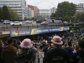 People stand at the top of the stairs from Wembley Park tube station as supporters arrive for an NFL football game between Seattle Seahawks and Oakland Raiders at Wembley stadium in London, Sunday, Oct. 14, 2018.