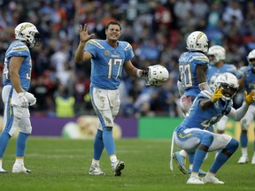 Los Angeles Chargers quarterback Philip Rivers (17), center, celebrates with teammates after a successful defensive play near the end of the second half of an NFL football game against Tennessee Titans at Wembley stadium in London, Sunday, Oct. 21, 2018. Los Angeles Chargers won the match 20-19.