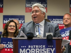 FILE- This June 5, 2018 file photo shows West Virginia Attorney General and GOP Senate candidate Patrick Morrisey at a press conference in Charleston, W.Va. U.S. Sen. Joe Manchin of West Virginia, facing a tough re-election in a state President Trump won by 42 percentage points in 2016, has written a series of op-ed pieces with Republican senators this week as a show of his bipartisan efforts.