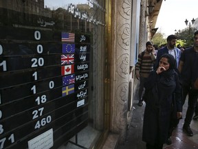 FILE - In this Oct. 2, 2018, file photo, an exchange shop displays rates for various currencies, in downtown Tehran, Iran. A battle is brewing between the Trump administration and some of the president's biggest supporters in Congress who are concerned that sanctions to be re-imposed on Iran early next month won't be tough enough.
