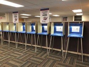 In this Sept. 20, 2018 photo, voting booths stand ready in downtown Minneapolis for the opening of early voting in Minnesota. Minnesota and South Dakota are tied for the earliest start in the country for early voting in the 2018 midterm elections. A new poll finds that a large majority of Americans are concerned the nation's voting systems might be vulnerable to hackers, with Democrats more concerned than Republicans.