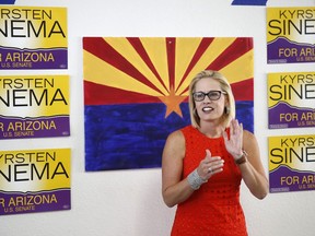 FILE - In this Aug. 28, 2018, file photo, Rep. Kyrsten Sinema, D-Ariz., talks to campaign volunteers at a Democratic campaign office in Phoenix. As the November elections near, Democrats are focusing on health care. It's been a constant drumbeat since the GOP launched its effort to repeal the Obama-era health law and is the subject of the greatest share of political ads on television now. It's a top issue in campaigns from Virginia to Nebraska to California, and especially in Arizona, where Democratic Rep. Kyrsten Sinema has made it the foundation of her Senate campaign.