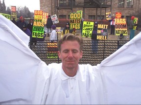 FILE - In this April 5, 1999 file photo, Ron Wilcoxson stands dressed as an angel as a response to anti-gay protesters from Westboro Baptist Church before the trial of one of two men accused of beating Matthew Shepard to death, in Laramie, Wyo.  The murder of the gay University of Wyoming student was a watershed moment for gay rights and LGBTQ acceptance in the U.S., so much so that 20 years later the crime remains seared into the national consciousness.