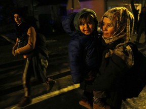 A migrant woman walks with her daughter on her way toward the border crossing of Izacici, Bosnia, on Monday, Oct. 22, 2018. Several dozen migrants, including women and children, have arrived near the border with Croatia after walking for several hours from a migrant center in Bosnia, Bosnian police on Monday evening stopped the migrants before they reached the border crossing in the village of Izacic, in northwestern Bosnia.