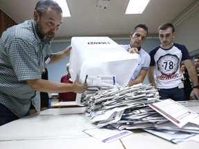 Bosnian election workers prepare to count ballots at a polling station in Sarajevo, Bosnia, on Sunday, Oct. 7, 2018. Bosnians decide in a tense election this weekend whether to cement the ethnic divisions stemming from the 1992-95 war by supporting nationalist politicians or push for changes that would pave the way toward European Union and NATO integration.
